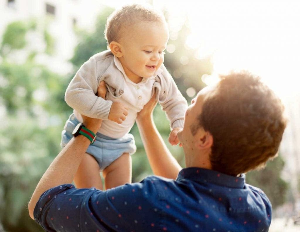 Father holding up young toddler son