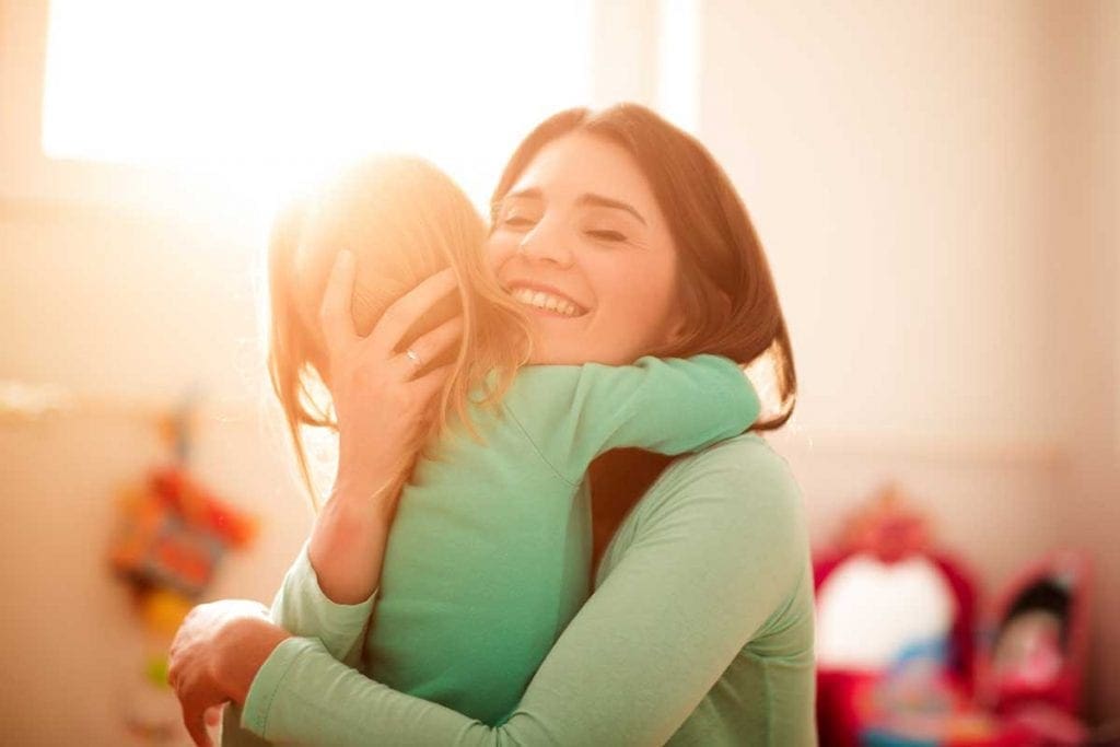 Woman smiling and hugging child