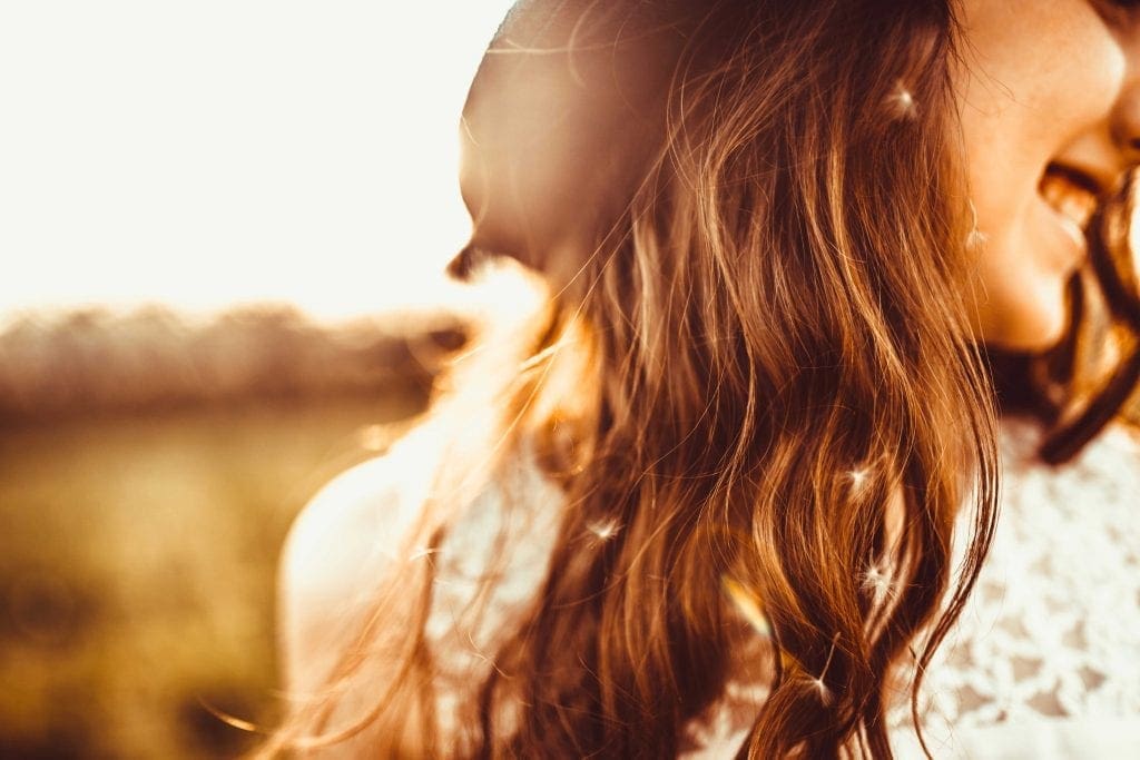 teenage girl smiling with closeup on her brown long hair